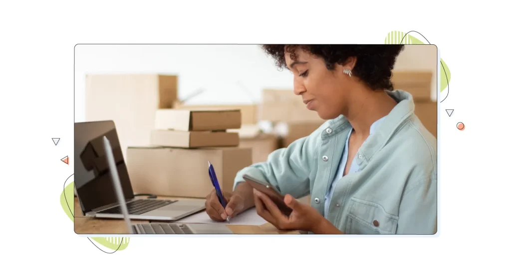 Young startup owner holding smartphone and checking order details.